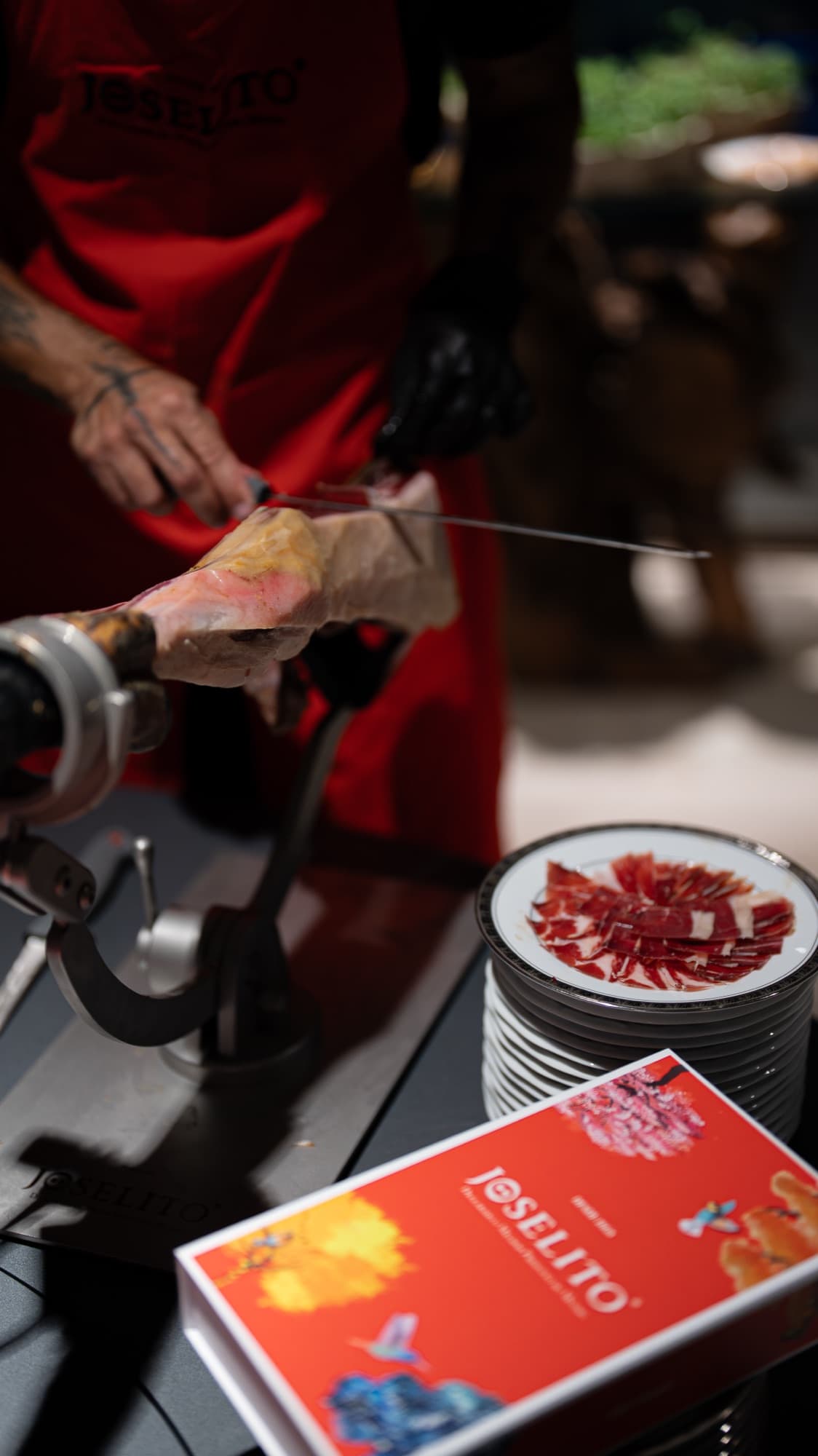 Mestre cortador fatiando jamón ibérico à mão em um evento Joselito